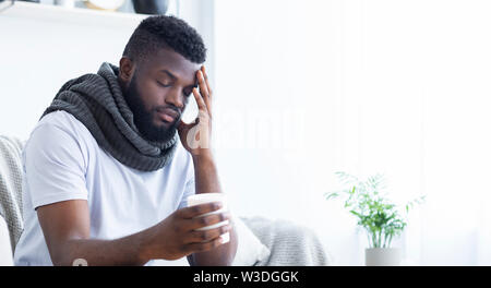 Triste afro-americano con flu coppa di ritegno con tè caldo Foto Stock