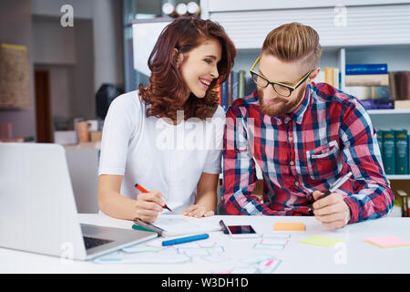 Due lieti di graphic designer progettazione di nuovi layout applicazione Foto Stock