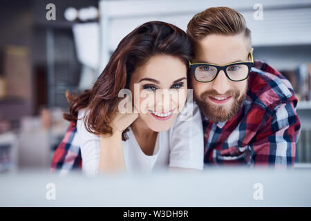 Tanga felice coppia in cerca di un portatile Foto Stock