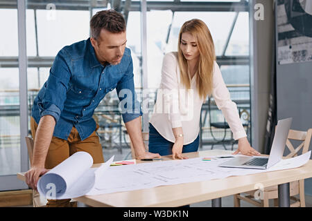 Due architetti che lavorano sul nuovo design presso un ufficio moderno Foto Stock