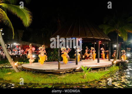 Gruppo di ballerini polinesiano di eseguire su un palco galleggiante presso la popolare spettacolo turistico di Te Vara Nui Village, la festa, Rarotonga Isole Cook, P Foto Stock