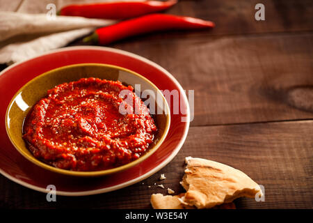 Una sana piccante, cremosa snack vegetariano con arrosti di pepe rosso dip con harissa,pita e olive che è rapido e facile da preparare Foto Stock