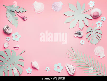 Cornice di conchiglie di mare e foglie tropicali sul rosa pastello sfondo, vista dall'alto. Layout creativi. Lay piatto. Concetto di estate Foto Stock