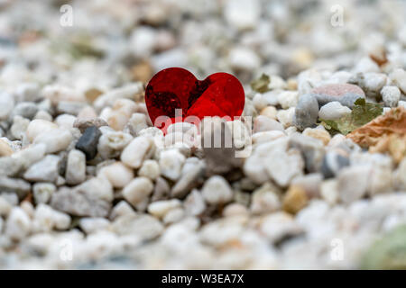 Un solitario rosso cuore di lamina a sinistra su un sentiero di ghiaia dopo un weddingfocused Foto Stock