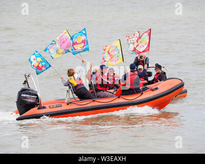 Sheerness, Kent, Regno Unito. Il 15 luglio 2019. T100 Walking Festival è organizzato dal gruppo di arti Kinetika, dotate di una serie di quindici giorni di passeggiate su entrambi i lati dell'estuario del Tamigi. Oggi, organizzatori e partecipanti hanno attraversato l'estuario del Tamigi con l aiuto dell'estuario del Tamigi Yacht Club (Essex) in due delle loro barche & lo sbarco a Isle of Sheppey Sailing Club di scalo in Sheerness, Kent, per incontrarsi con gli altri escursionisti che partecipano oggi a piedi da Sheerness alla Cattedrale sul mare. Credito: James Bell/Alamy Live News Foto Stock