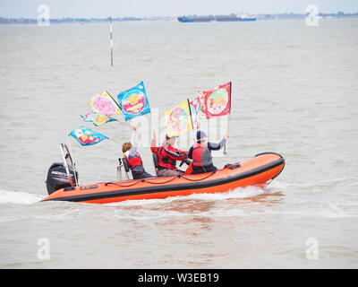 Sheerness, Kent, Regno Unito. Il 15 luglio 2019. T100 Walking Festival è organizzato dal gruppo di arti Kinetika, dotate di una serie di quindici giorni di passeggiate su entrambi i lati dell'estuario del Tamigi. Oggi, organizzatori e partecipanti hanno attraversato l'estuario del Tamigi con l aiuto dell'estuario del Tamigi Yacht Club (Essex) in due delle loro barche & lo sbarco a Isle of Sheppey Sailing Club di scalo in Sheerness, Kent, per incontrarsi con gli altri escursionisti che partecipano oggi a piedi da Sheerness alla Cattedrale sul mare. Credito: James Bell/Alamy Live News Foto Stock