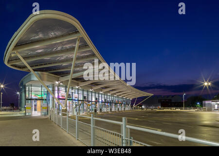 Il primo bus travel shop presso il disco Interchange in Portsmouth durante la notte Foto Stock