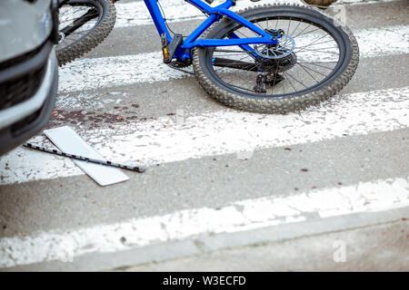 Scena di un incidente stradale con auto e biciclette rotte giacente sul passaggio pedonale Foto Stock