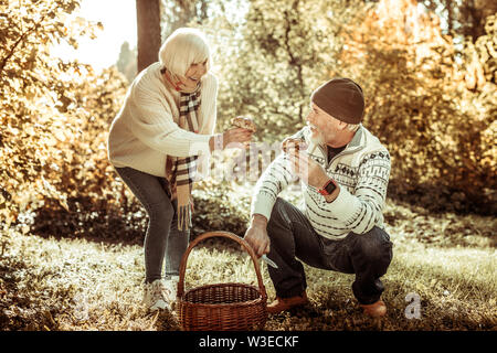 Coppia felice che mostra ogni altri funghi che hanno trovato. Foto Stock