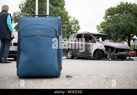 Il 15 luglio 2019, Schleswig-Holstein, Lubecca: La valigia di Jürgen Hinsch da Hannover sorge accanto al suo bruciate le auto VW, che egli aveva parcheggiato in un parcheggio nei pressi della città vecchia isola. Egli ha visitato la Schleswig-Holstein Music Festival con la moglie. Autori sconosciuti impostare diverse vetture sul fuoco vicino alla musica e Sala Congressi di lunedì sera. Un totale di una dozzina di auto sono state bruciata o danneggiata, un portavoce per i vigili del fuoco detto. Il dipartimento dei vigili del fuoco è assumendo arson. Che il fuoco è stato inizialmente poco chiaro. Foto: Rainer Jensen/dpa Foto Stock