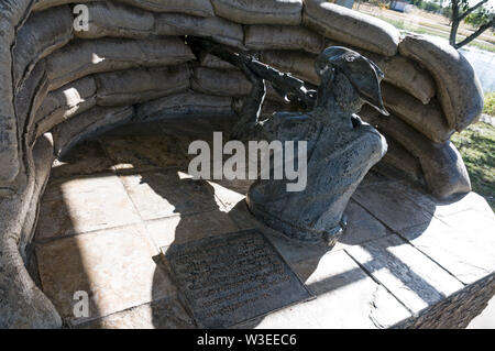 Una statua di una prima Guerra Mondiale soldato australiano di puntamento di un fucile dietro un contrappeso la cottura post nel parco centenario, Clermont, Queensland Highlan centrale Foto Stock