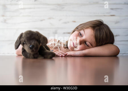 Ritratto di bella, premuroso, annoiato bambina con la sua preferita giocattolo morbido, fantasticando e la creazione di idee nella sua mente. Processo creativo. Soft fo Foto Stock