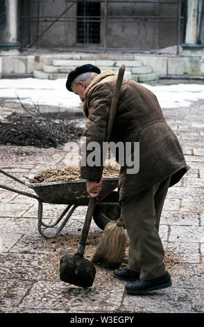 5 aprile 1993 durante l'assedio di Sarajevo: un uomo vecchio spazia fino trucioli di legno nel cortile di Gazi Husref-mendicare la moschea in Bascarsija. Senza elettricità, molti di Sarajevo gli alberi sono stati tagliati per legna da ardere e ogni scheggia di legno è stato salvato. Foto Stock