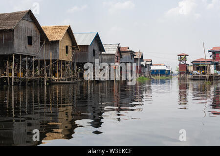 Maing Thauk, Myanmar - Aprile 2019: tradizionale birmana casa galleggiante riflettendo in acqua di Lago Inle. Foto Stock