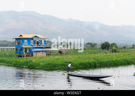 Maing Thauk, Myanmar - Aprile 2019: tradizionale birmana casa galleggiante riflettendo in acqua di Lago Inle. Foto Stock