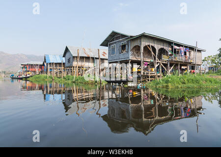 Maing Thauk, Myanmar - Aprile 2019: tradizionale birmana casa galleggiante riflettendo in acqua di Lago Inle. Foto Stock