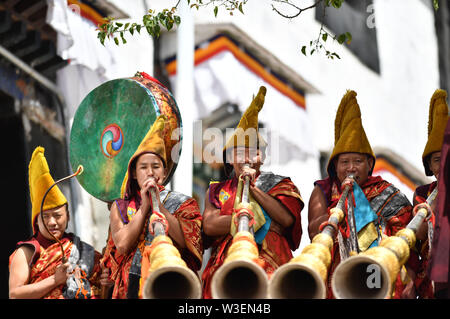 Xigaze, la Cina della regione autonoma del Tibet. Il 15 luglio 2019. I monaci frequentare un display Thangka rituale al monastero di Tashilhunpo in Xigaze, a sud-ovest della Cina di regione autonoma del Tibet, luglio 15, 2019. Thangka sono Buddista Tibetana opere dipinte su cotone o seta. I dipinti di soggetto religioso può essere fatta risalire al X secolo e tipicamente rappresentano Divinità buddiste. Credito: Chogo/Xinhua/Alamy Live News Foto Stock