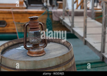 una botte di vino in legno e metallo usata come tavolo sul ponte di legno  del caffè. Terrazza con tavolo a botte. Un vecchio barile usato come mobili  Foto stock - Alamy