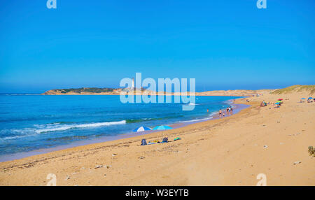 Vista panoramica della baia di Varadero, spiaggia Marisucia con il faro di Trafalgar in background. Los Canos de Meca Barbate, Cadiz, Spagna. Foto Stock