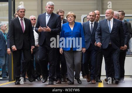 Görlitz, in Sassonia, Germania. Il 15 luglio 2019. Scheda di Siemens stati Joe Kaeser (l-r), Ronald Schmidt, capo dell'impianto di Siemens in Görlitz, il Cancelliere tedesco Angela Merkel (CDU), il futuro sindaco di Görlitz Ottaviano Ursu (CDU), e Siegfried Deinege (non-partito), Sindaco di Görlitz, a piedi attraverso una sala di produzione. Un mese e mezzo prima della elezioni di stato della Sassonia, Merkel visite la pianta di Siemens nel libero Stato di Sassonia così come rete di donne riuniti nella capitale dello stato. Foto: Sebastian Kahnert/dpa-Zentralbild dpa/credito: dpa picture alliance/Alamy Live News Foto Stock