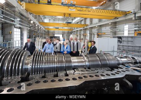 Görlitz, in Sassonia, Germania. Il 15 luglio 2019. Il Cancelliere federale Angela Merkel (CDU, m) sorge nella parte anteriore di una turbina presso la Siemens Görlitz impianto a fianco di Michael Kretschmer (CDU, quinto da sinistra), il primo ministro del Land di Sassonia e Ronald Schmidt (terzo da destra), Plant Manager. Un mese e mezzo prima della elezioni di stato della Sassonia, Merkel visite la pianta di Siemens nel libero Stato di Sassonia così come rete di donne riuniti nella capitale dello stato. Foto: Sebastian Kahnert/dpa-Zentralbild dpa/credito: dpa picture alliance/Alamy Live News Foto Stock