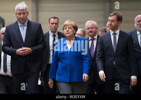 Görlitz, in Sassonia, Germania. Il 15 luglio 2019. Il Cancelliere federale Angela Merkel (CDU) passeggiate attraverso una sala di produzione al fianco di Michael Kretschmer (CDU, r), il primo ministro del Land di Sassonia e Ronald Schmidt (l), la testa dell'impianto di Siemens in Görlitz. Un mese e mezzo prima della elezioni di stato della Sassonia, Merkel visite la pianta di Siemens nel libero Stato di Sassonia così come rete di donne riuniti nella capitale dello stato. Foto: Sebastian Kahnert/dpa-Zentralbild dpa/credito: dpa picture alliance/Alamy Live News Foto Stock