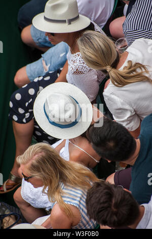 Birds Eye view di spettatori, indossare cappelli e utilizzando il telefono cellulare, a Wimbledon Tennis Championship Foto Stock