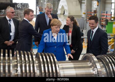 Görlitz, in Sassonia, Germania. Il 15 luglio 2019. Il Cancelliere federale Angela Merkel (CDU) sta di fronte ad una turbina presso la Siemens Görlitz impianto a fianco di Michael Kretschmer (CDU, la seconda da sinistra), il primo ministro del Land di Sassonia e Ronald Schmidt (terza da sinistra), Plant Manager. Un mese e mezzo prima della elezioni di stato della Sassonia, Merkel visite la pianta di Siemens nel libero Stato di Sassonia così come rete di donne riuniti nella capitale dello stato. Foto: Sebastian Kahnert/dpa-Zentralbild dpa/credito: dpa picture alliance/Alamy Live News Foto Stock