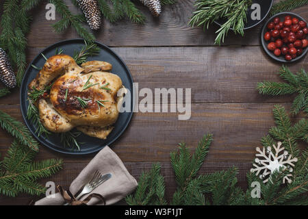 Natale tradizionale tacchino arrosto con spezie e rosmarino su un tavolo di legno. Vista dall'alto. Spazio per il testo. Xmas. Foto Stock