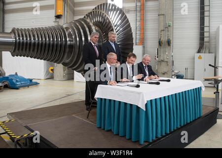 Görlitz, in Sassonia, Germania. Il 15 luglio 2019. Scheda di Siemens stati Joe Kaeser (l-r), Armin Schnettler, Siemens Energy Research, Ronald Schmidt, capo dell'impianto di Siemens, Michael Kretschmer (CDU), il primo ministro del Land di Sassonia e Fraunhofer presidente Reimund Neugebauer firmare un patto per il futuro in una sala di produzione. Un mese e mezzo lo stato prima delle elezioni in Sassonia, il Cancelliere Merkel visiti la Siemens impianto nella città Neisse di Görlitz e la rete di donne riuniti nella capitale dello stato. Foto: Sebastian Kahnert/dpa-Zentralbild dpa/credito: dpa picture alliance/Alamy Live News Foto Stock