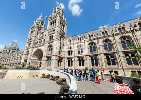 Museo di Storia Naturale di Londra esterno; le persone al di fuori di entrare nel museo, attraverso l'ingresso principale su Exhibition Road, South Kensington London REGNO UNITO Foto Stock