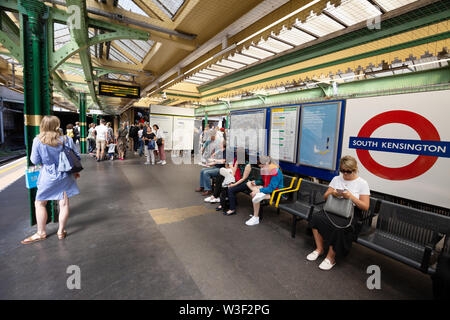 La stazione di South Kensington; persone in attesa sul binario presso la stazione della metropolitana di South Kensington, London REGNO UNITO Foto Stock