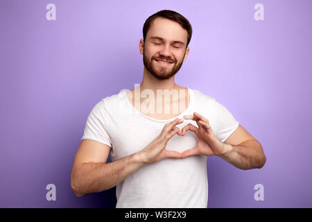 Uomo romantico che mostra il suo amore per una ragazza, una forte sensazione di caldo. close up ritratto, affetto . l uomo con gli occhi chiusi esprime il suo sentimento. isolare Foto Stock