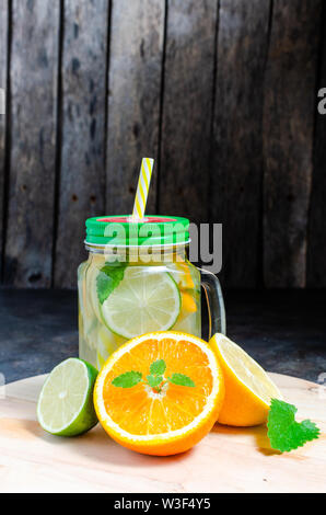 Possibile con il freddo e limonata fresca. Limone, arancio, cedro e menta su sfondo di legno. Foto Stock