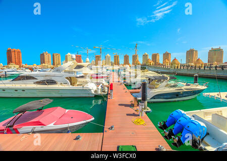 Doha, Qatar - 18 Febbraio 2019: Marina lungomare Corniche con barche di lusso e yacht in Porto Saudita all'Pearl-Qatar. Le torri residenziali su Foto Stock