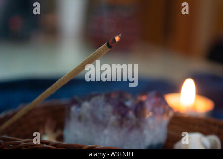 Close up di guarigione, aroma stick accanto ad un cristallo. Messa a fuoco selettiva, 'in casa' atmosfera. Foto Stock