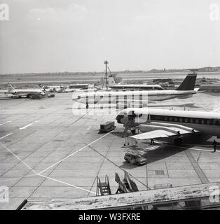 Anni sessanta, storico aeroporto di Londra, aerei parcheggiati accanto alla pista. Sviluppo dell'aeroporto era begain nel 1944 e nel 1966 essa è stata rinominata Heathrow Airport dopo un piccolo aeroporto è stato originariamente stabilito sulla terra agricola nella frazione o nel villaggio di tale nome nel Middlesex, Inghilterra. Foto Stock