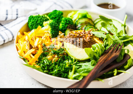 Insalata verde con broccoli, pasta di zucchine, avocado e condimento. Impianto basato dieta concetto. Foto Stock