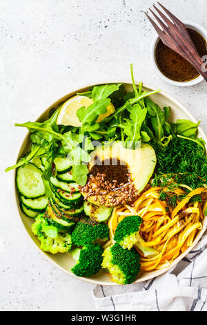 Insalata verde con broccoli, pasta di zucchine, avocado e condimento. Impianto basato dieta concetto. Foto Stock