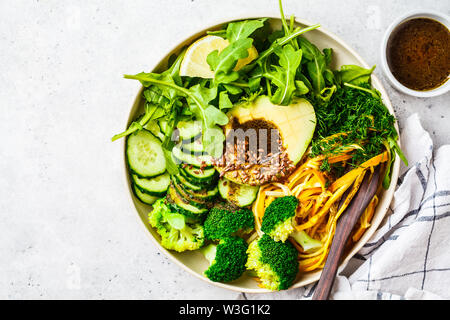 Insalata verde con broccoli, pasta di zucchine, avocado e condimento. Impianto basato dieta concetto. Foto Stock