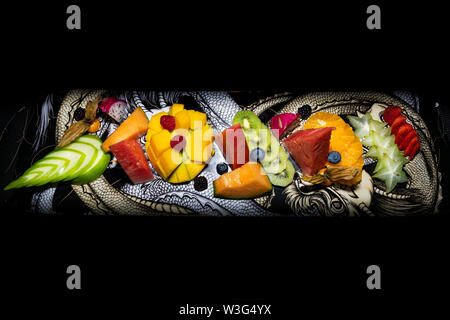 Un incredibile fresca e gustosa frutta tropicali piatto presentato su uno skateboard deck birds eye view Foto Stock