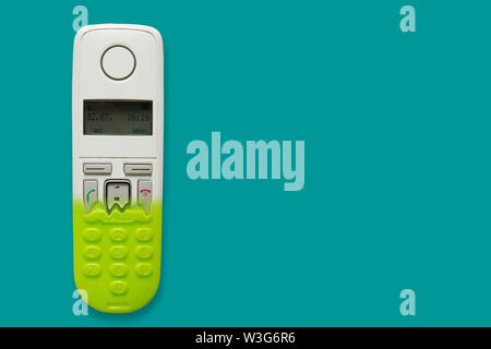 Il telefono DECT di trasformarsi in un giocattolo telefono isolato su sfondo blu. Il concetto di obsolescenza della tecnologia. Copia dello spazio. Foto Stock