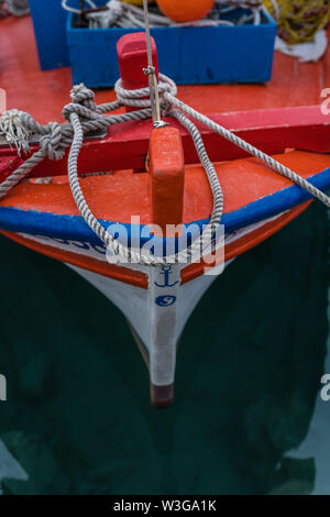 In prossimità di una parte anteriore di un piccolo vuoto fisherman barca ormeggiata in porto Foto Stock