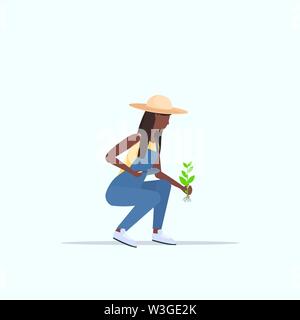 Femmina piantando agricoltore agricoltura giovani piantine americano africano donna lavora in giardino lavoratore agricolo in uniforme eco concetto di agricoltura Illustrazione Vettoriale