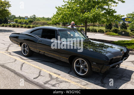 Un uomo si mette in mostra la sua splendidamente personalizzato nero 1968 Chevrolet Impala parcheggiata in Fort Wayne, Indiana, Stati Uniti d'America. Foto Stock