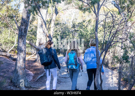 La madre e le figlie a piedi il sentiero a Wineglass Bay in Tasmania, Australia su un soleggiato inverni giorno Foto Stock