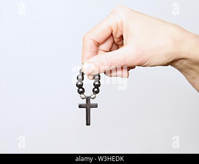 Donna che prega insieme a mano protesa con il crocifisso e il rosario croce immagine stock e stock photo Foto Stock