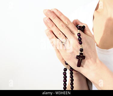 Donna che prega insieme a mano protesa con il crocifisso e il rosario croce immagine stock e stock photo Foto Stock