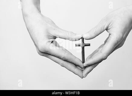 Donna che prega insieme a mano protesa con il crocifisso e il rosario croce immagine stock e stock photo Foto Stock