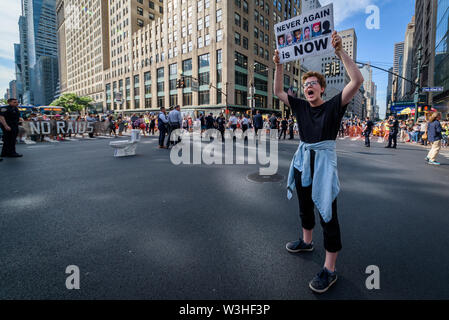 New York, Stati Uniti d'America. Il 15 luglio 2019. Più di 40 membri dell'azione diretta di gruppo e aumento di resist sono stati arrestati dopo la chiusura di ora di punta del traffico in corrispondenza dell'intersezione tra la 42nd Street e la Fifth Avenue nel cuore di New York City sulla luglio 15, 2019 raccomanda per i diritti degli immigrati ed esigente pubblico wake up, agire, e alla fine la crisi di confine il terrore e il terrore inflitti alla comunità di immigrati. Gli attivisti detenuti tre banner che leggere, 'chiudere i campi'', 'No incursioni'', e 'abolire il ghiaccio''. Alcuni membri indossava inoltre fluorescente giubbotti di lavoro con le parole 'abolire il ghiaccio. (Credito Foto Stock